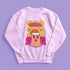 A holiday sweatshirt featuring a cute ghost character wearing a Santa hat, with two smaller ghosts on either side. Above them is the playful text "Boo Humbug," surrounded by snowflakes and festive elements. The design humorously combines spooky and festive themes for a unique holiday look.